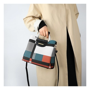 Detail of crossbody bag featuring geometric color blocks and lychee texture leather
