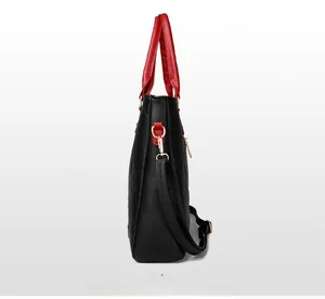Detail of lychee pattern leather handbag with 3D embossed clover and red handles