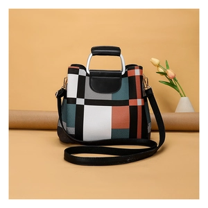 Detail of the chic geometric color-block handbag with metallic handle and gold hardware