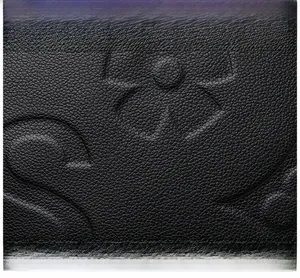 Close-up of premium black embossed leather handbag featuring detailed floral textures