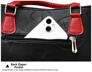 Detail of the back zipper pocket on a black pebble leather handbag with phone storage