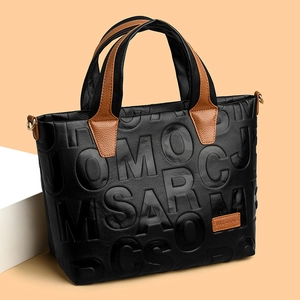 Fashionable black leather tote bag with embossed letters and contrasting brown handles