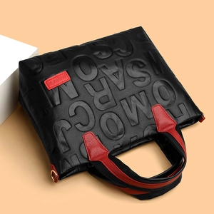 Fashion tote bag with black embossed leather, red contrast accents and gold hardware