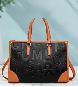 Détail du motif gaufré sur le sac cabas bicolore en cuir avec poignées robustes
