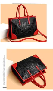 Détail du sac cabas en cuir grainé avec lettres embossées et coins rouges renforcés