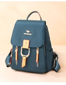 Détail d'un sac à dos vert foncé avec ferrures dorées et fermeture à rabat magnétique