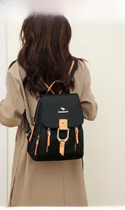Détail du sac à dos en nylon noir avec logo kangourou doré et bretelles contrastées