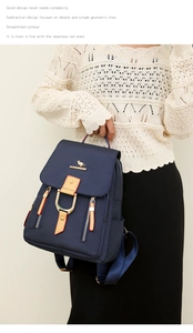 Détail d'un sac à dos bleu marine en nylon avec finitions dorées et cuir kaki