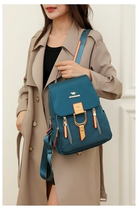 Détail du sac à dos en nylon bleu sarcelle avec garniture en cuir brun et métal doré