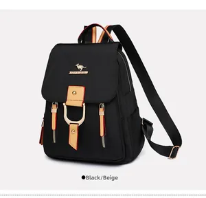 Détail d'un sac à dos en nylon noir avec logo kangourou doré et lanières en cuir marron