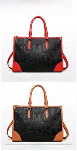 Détail du grand sac cabas avec motif texte en relief et poignées à coutures contrastées