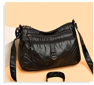 Detail of black multi-zip shoulder bag with textured faux leather and silver hardware