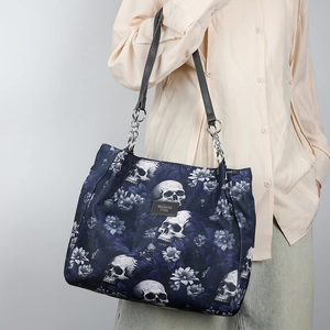 Gothic skull and floral print large tote bag with silver chain strap shown on model