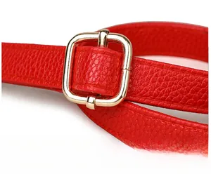 Détail de la bandoulière en cuir rouge grainé avec boucle carrée dorée réglable
