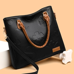 Black embossed faux leather handbag for women with brown handles and gold hardware