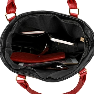 Spacious black pebbled leather tote bag with red handles and interior pocket detail