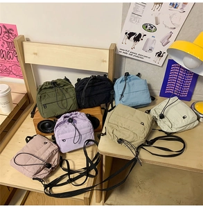 Detailed arrangement of colorful nylon drawstring crossbody bags in seven vibrant colors