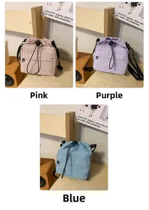 Detailed view of colorful nylon drawstring mini crossbody bags in pink, purple, and blue