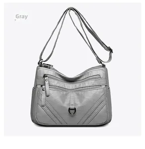 Detailed front view of gray multi-layer crossbody bag with premium pebbled texture