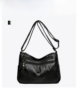 Close-up of black PU leather crossbody bag with multiple zippers and pebble texture