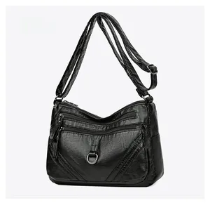 Close-up of black multi-compartment shoulder bag with soft textured PU leather and zippers