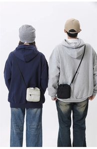 Dual view of minimalist drawstring nylon phone bags in black and off-white colors