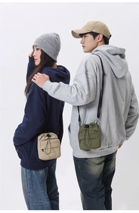 Detail of khaki and army green nylon drawstring crossbody bags with front zipper pockets