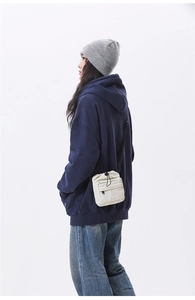 Neutral off-white nylon crossbody bag with drawstring closure and front zipper pocket