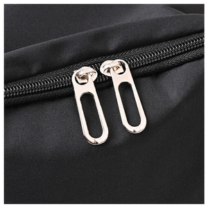 Detail of silver dual metal zippers on high-density black nylon travel backpack