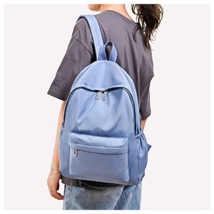 Side view of light blue oxford backpack with water-resistant fabric and side pockets