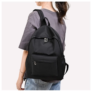 Detailed view of the black Oxford cloth backpack showing side pocket and front zipper
