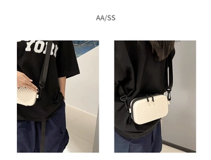Detail of cream hard shell crossbody bag featuring textured waves and double zip closure