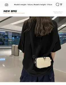 Hard shell crossbody bag in cream white with textured stripes shown on a model