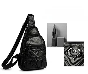Detail of black soft PU leather chest bag featuring heart metal buckle and multi-zipper pockets