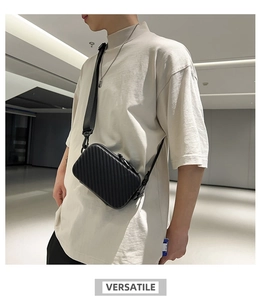 Close-up of black hard-shell crossbody bag featuring iconic vertical stripe design