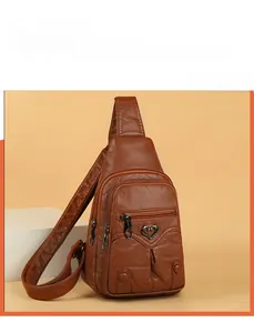 Detail view of brown PU leather crossbody bag featuring heart metal buckle and multi-zippers
