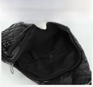 Interior detail of black quilted faux leather sling bag with internal zipper pocket