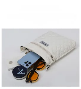 Capacité du sac à bandoulière matelassé blanc avec téléphone, lunettes et maquillage