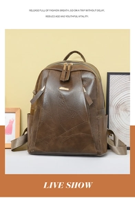 Detail of vintage brown PU leather backpack featuring side pockets and gold zipper accents