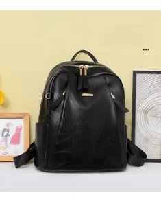 Detail view of black PU leather backpack with vintage leaf stitching and gold hardware