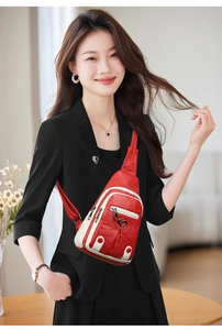 Close-up of red PU leather chest bag with heart zipper and white trim detail on a model