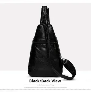 Detail view of the back side of black PU leather sling bag with functional zipper pocket