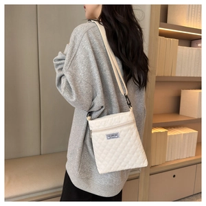 Sac bandoulière matelassé à losanges avec sangle réglable porté par un mannequin