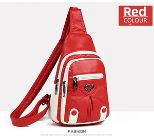 Detailed side view of red PU leather sling bag showing textured finish and heart buckle