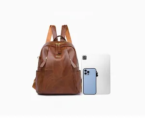 Brown PU leather backpack detail showing interior space fitting an iPad Pro and smartphone