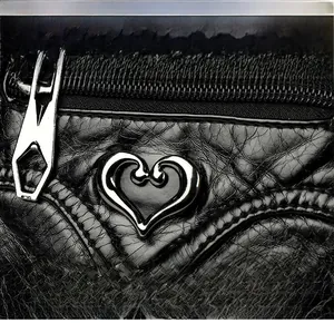 Close-up of litchi texture PU leather bag with silver heart-shaped metal ornament