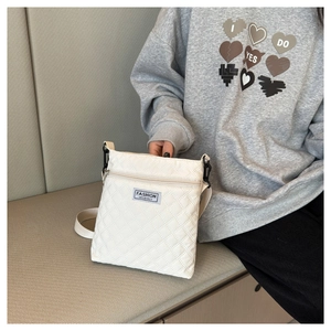 Gros plan sur un sac bandoulière blanc matelassé avec étiquette fashion instinct devant
