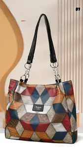 Detail of geometric patchwork tote with embossed leather texture and silver chain strap