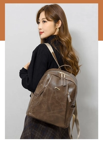 Detail of dark brown vintage PU leather backpack with patchwork design and gold zippers