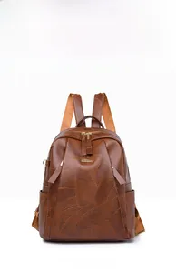 Front view of a brown vintage PU leather backpack with geometric texture and metal zippers